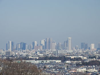 Aerial view of buildings in city against clear sky