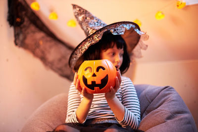 Halloween kids.cute little girl sitting with a bucket of pumpkin
