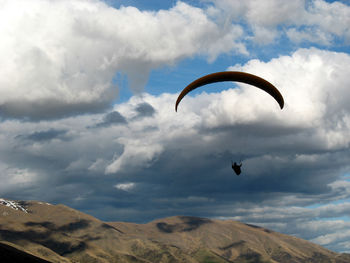 Person paragliding against sky