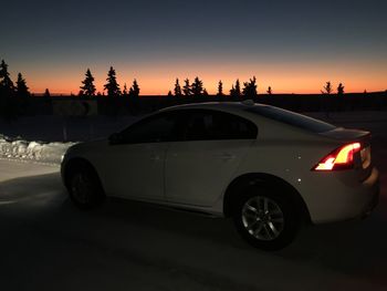 Car parked on road at sunset