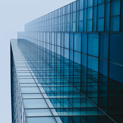 Low angle view of office building against blue sky