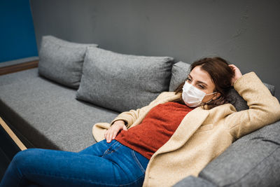 Portrait of woman lying on sofa at home
