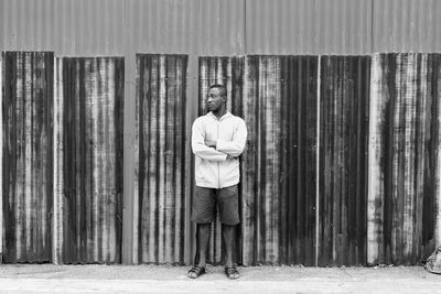 Portrait of young man standing against wall