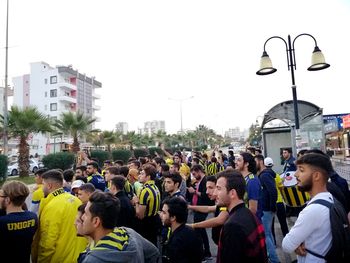 People on city street against clear sky