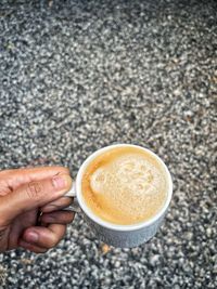 Cropped image of hand holding coffee cup