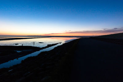 Scenic view of landscape against blue sky during sunset