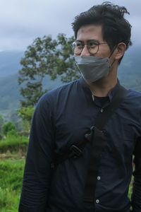 Portrait of young man wearing sunglasses against sky