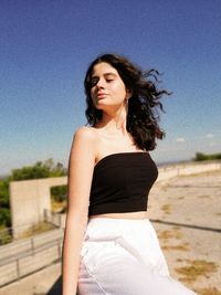 Beautiful woman standing against clear sky