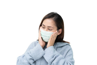 Portrait of young woman wearing hat against white background