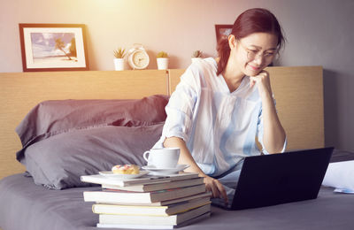 Young woman using mobile phone at home