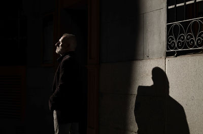 Adult man in suit on street in winter with sunlight and shadow