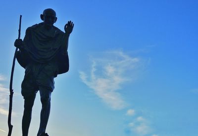 Low angle view of man holding blue sky