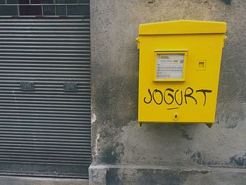 Yellow mailbox on wall