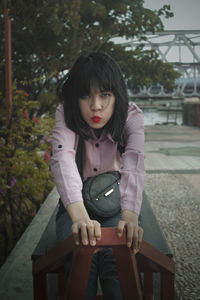 Portrait of a young woman sitting on bench