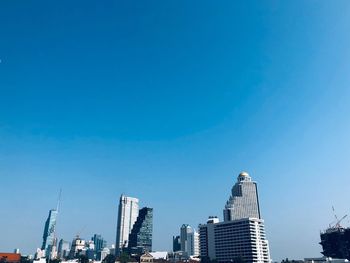 Low angle view of buildings against clear blue sky