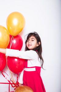 Portrait of a smiling young woman holding balloons