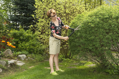 Full length of woman standing by tree