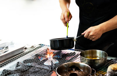 Midsection of man preparing food in kitchen