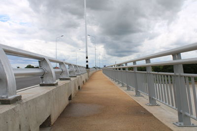 View of empty bridge against cloudy sky