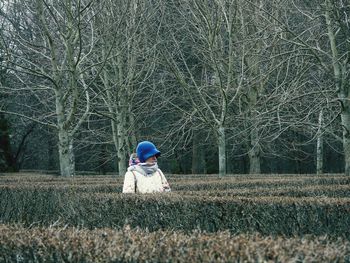 Rear view of woman sitting on field