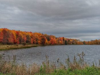 Scenic view of lake against cloudy sky during autumn