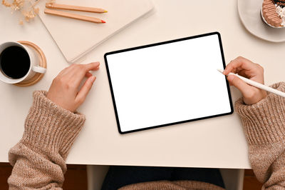 High angle view of woman using digital tablet on table