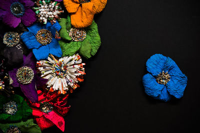 Close-up of colorful artificial flowers on black background