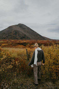 View from behind on woman overlooking the mountain during autumn in iceland