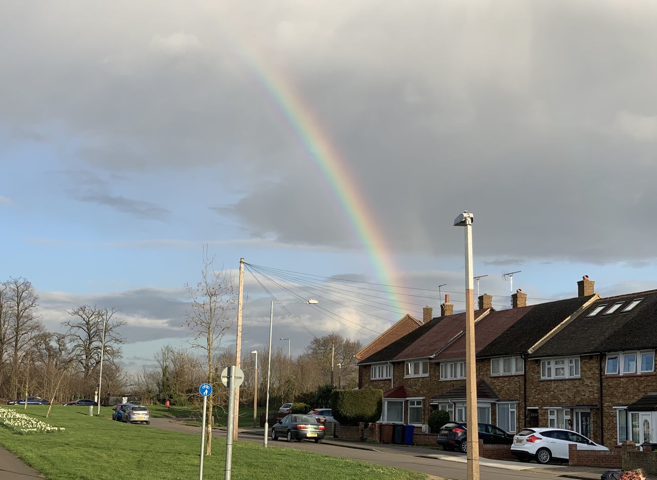 SCENIC VIEW OF RAINBOW OVER STREET AND BUILDINGS