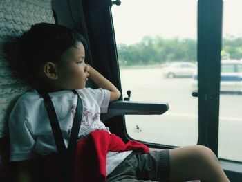 Rear view of boy sitting in car