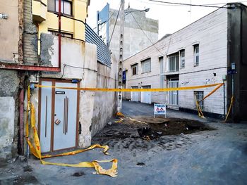 Crime tape amidst buildings on street