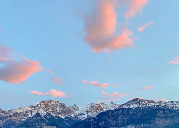 Low angle view of snowcapped mountains against sky