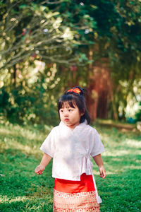 Portrait of young woman standing on field