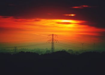 Silhouette electricity pylon against sky during sunset