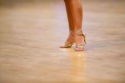 Low section of woman wearing high heels dancing on floor