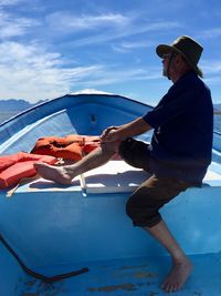 People on shore against blue sky