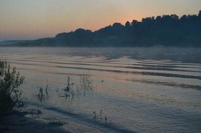 Scenic view of calm lake at sunset