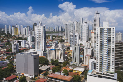 Aerial view of buildings in city against sky