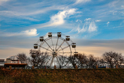 Ferris wheel on field against sky during sunset