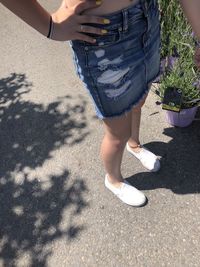 Low section of woman standing on road