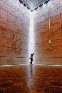 Full length of man walking against wall