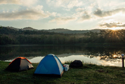 Tent by lake against sky