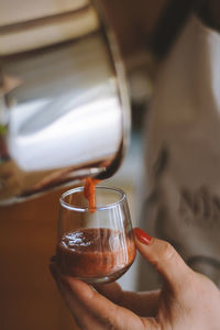 Midsection of woman pouring sauce in bowl