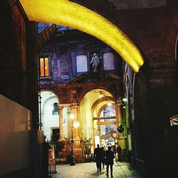 People in illuminated corridor