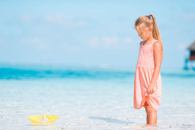 Portrait of young woman standing at beach