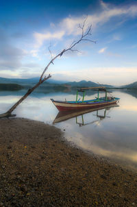 Boat moored on beach against sky