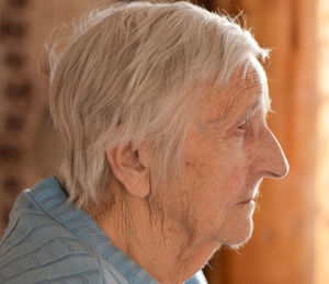 Portrait of an elderly 90-year-old lady in profile, with gray hair.