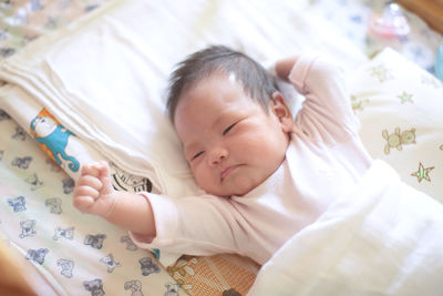 High angle view of baby sleeping on bed