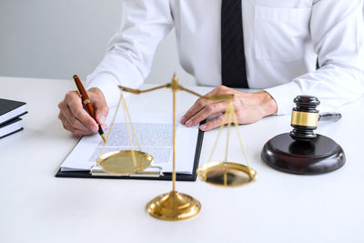 Midsection of man holding paper at table