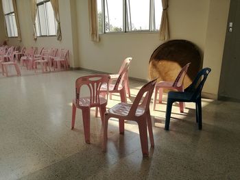Empty chairs and table by window